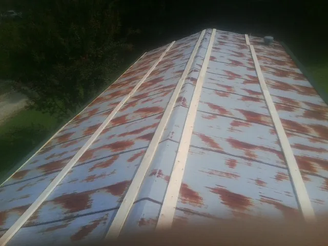 Rusted metal roof panels with new wood purlins before replacement — Storm Damage Roof Repair in Grand Bay by Roofing Brothers