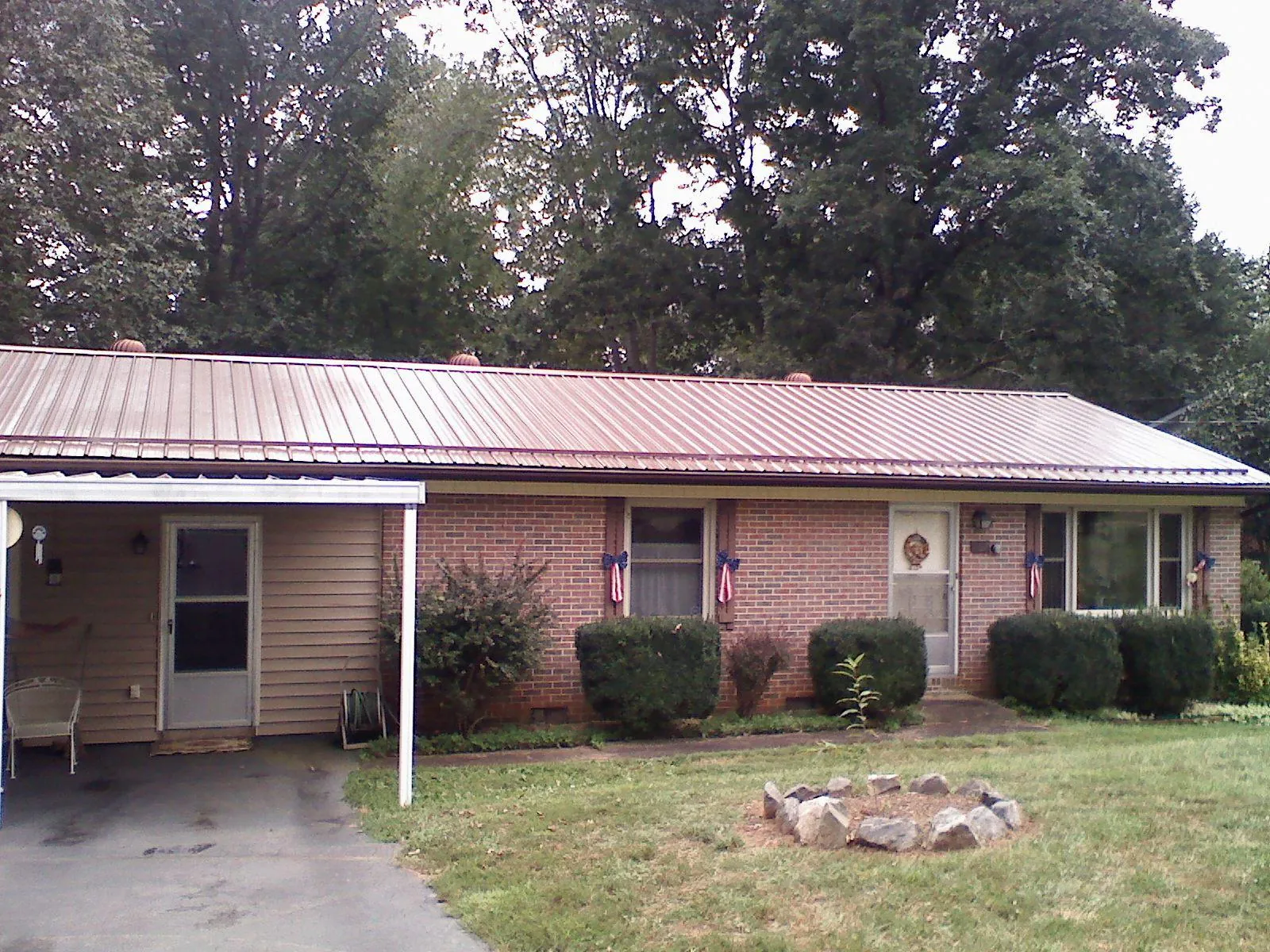 Bronze metal roof and carport on a brick ranch home — Roof Repair work by our crew in Grand Bay